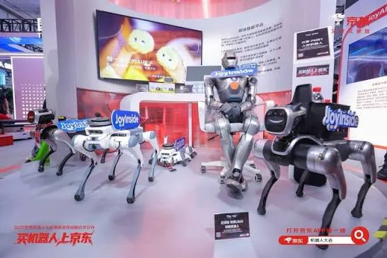 Robot dogs and a seated humanoid robot on display at a conference booth