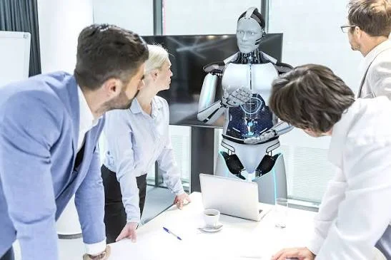 Business team gathered around a table looking at a humanoid robot during a corporate meeting