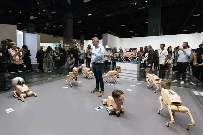 Robot dogs walking on an exhibition floor as visitors watch and take photos
