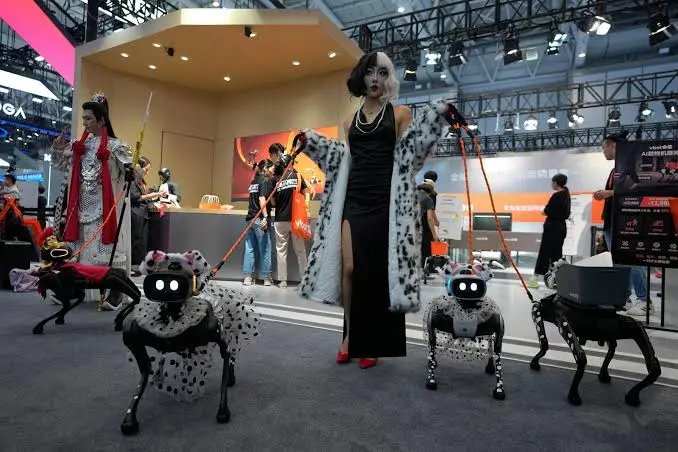 Performer in costume walking robot dogs on leashes at an event stand